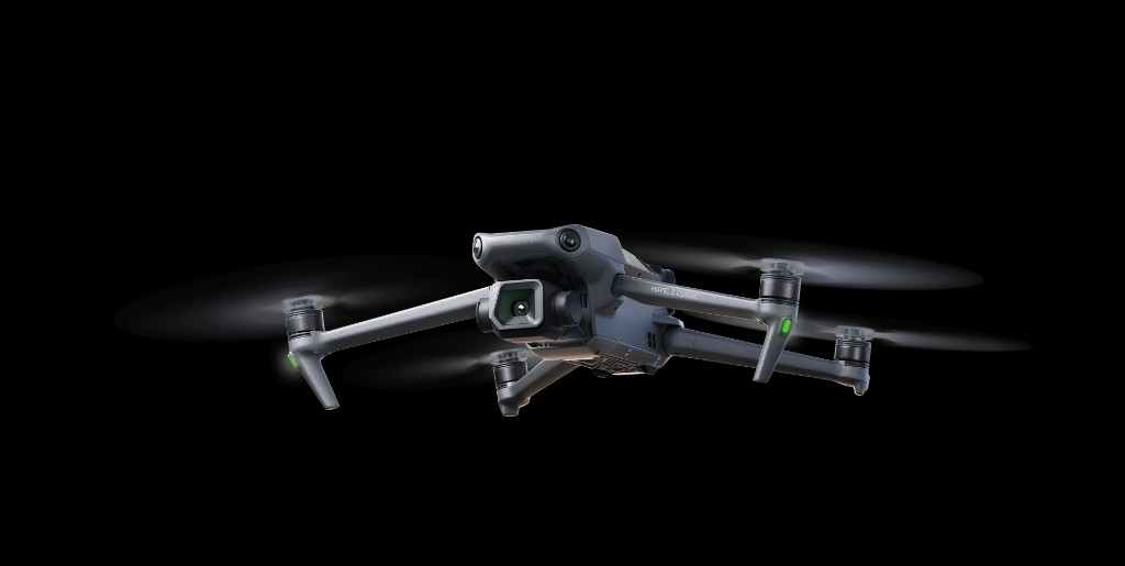 Drone DJI em primeiro plano sobre fundo escuro.